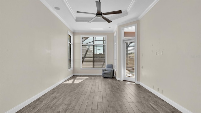 unfurnished room with hardwood / wood-style floors, crown molding, a tray ceiling, and ceiling fan