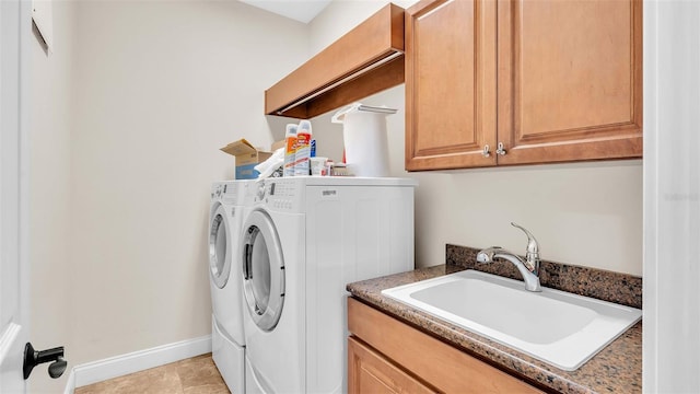 laundry area with sink, washing machine and dryer, light tile patterned floors, and cabinets