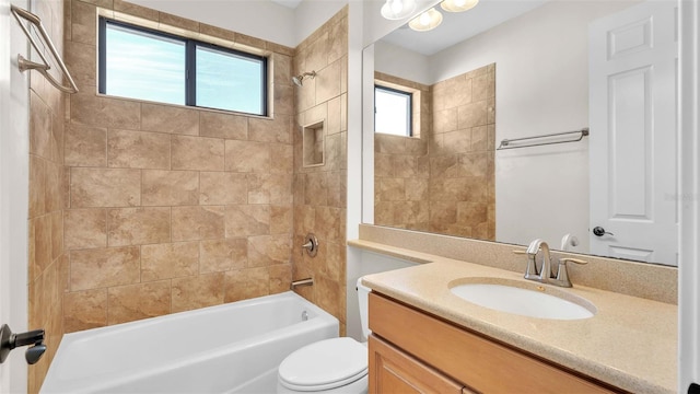 full bathroom with vanity, tiled shower / bath combo, and toilet