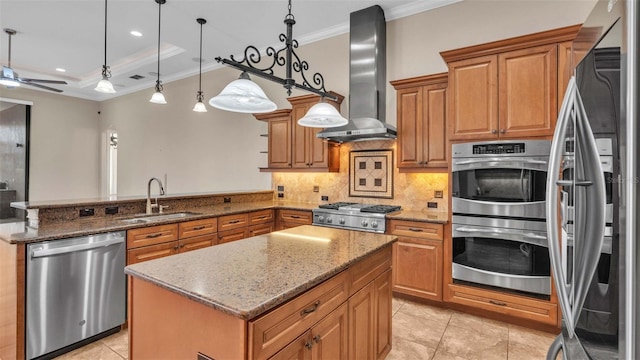 kitchen featuring sink, dark stone counters, a kitchen island, stainless steel appliances, and wall chimney range hood