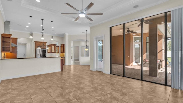 unfurnished living room featuring crown molding, a raised ceiling, and ceiling fan