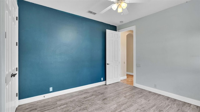 empty room with ceiling fan and light wood-type flooring