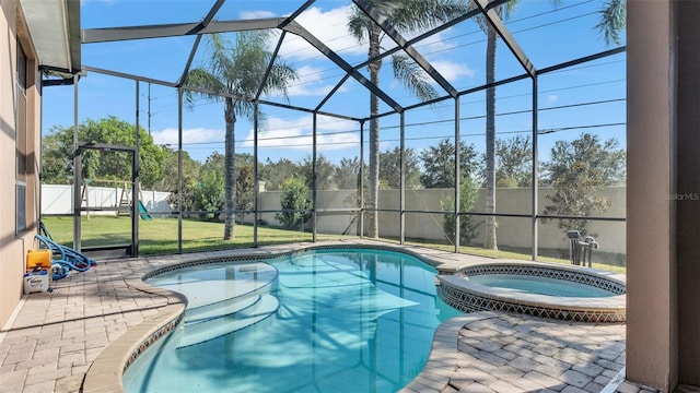 view of swimming pool featuring a yard, a lanai, an in ground hot tub, and a patio