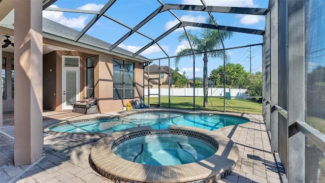 view of swimming pool with an in ground hot tub, a patio, a lanai, ceiling fan, and a lawn