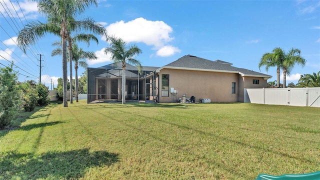 rear view of property featuring a lawn and glass enclosure