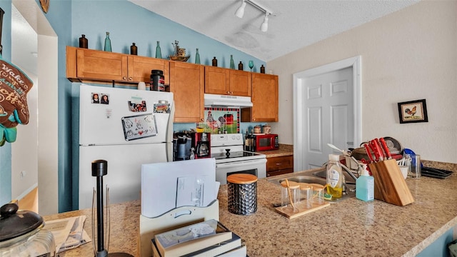 kitchen with white appliances, sink, a textured ceiling, kitchen peninsula, and vaulted ceiling