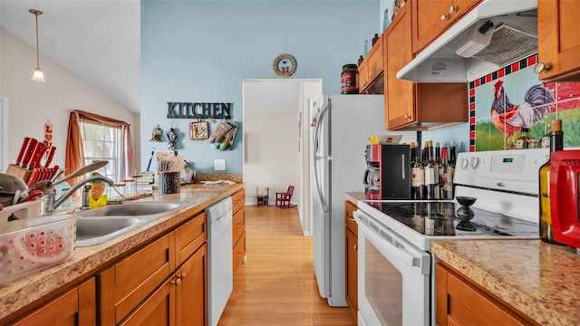 kitchen featuring lofted ceiling, light wood-type flooring, sink, decorative light fixtures, and white appliances