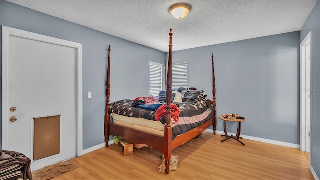 bedroom with a textured ceiling and hardwood / wood-style flooring