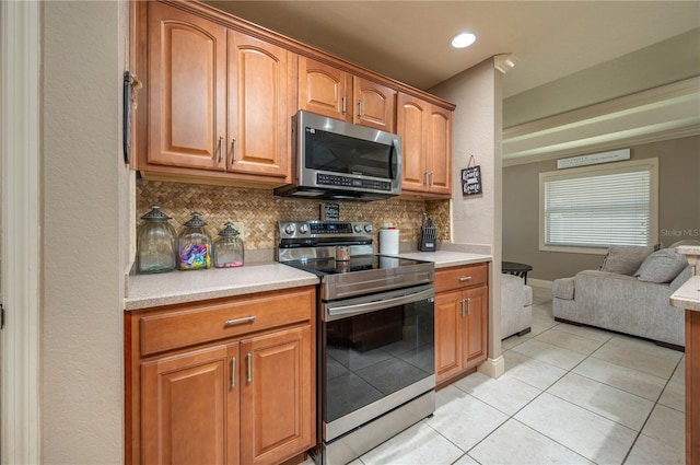 kitchen featuring backsplash, stainless steel appliances, and light tile patterned flooring