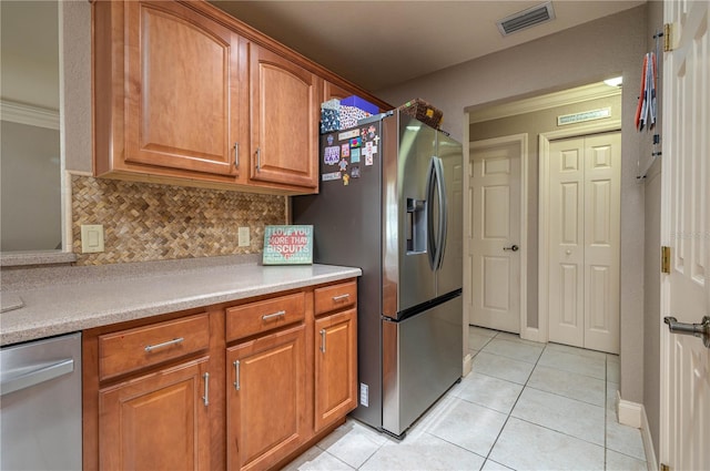 kitchen with light tile patterned floors, stainless steel fridge, and decorative backsplash