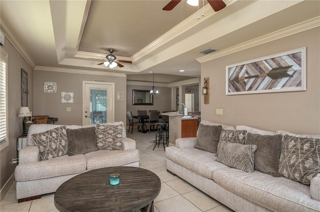 tiled living room with a raised ceiling, crown molding, and ceiling fan