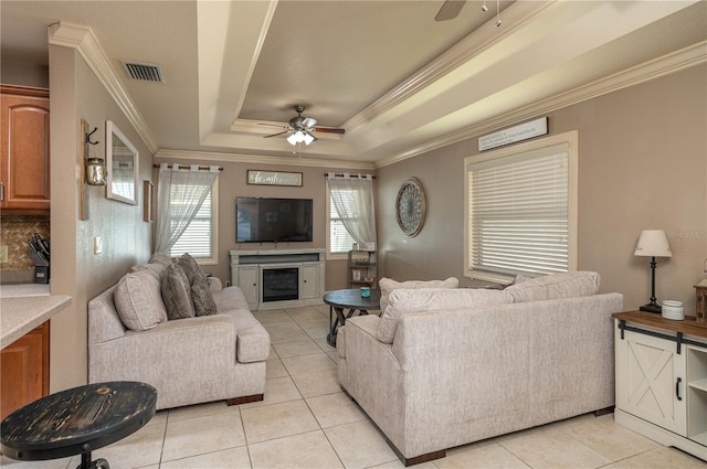 living room with ceiling fan, ornamental molding, and a tray ceiling