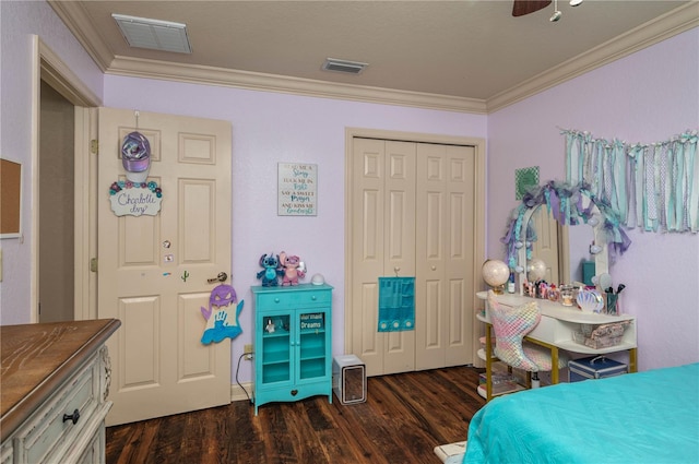 bedroom featuring crown molding, dark hardwood / wood-style floors, ceiling fan, and a closet