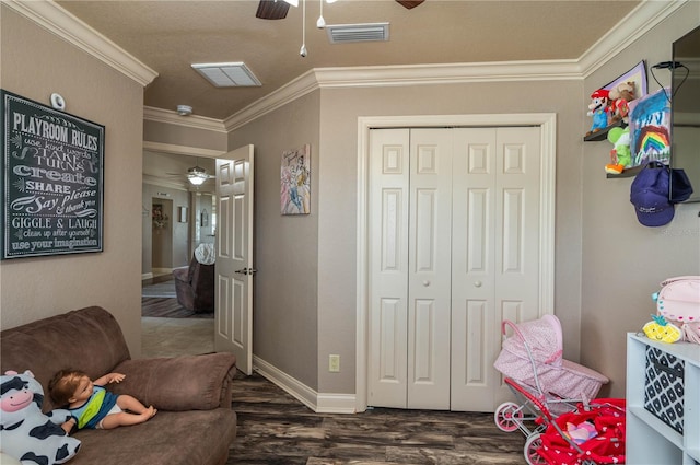 playroom with crown molding, dark hardwood / wood-style floors, and ceiling fan