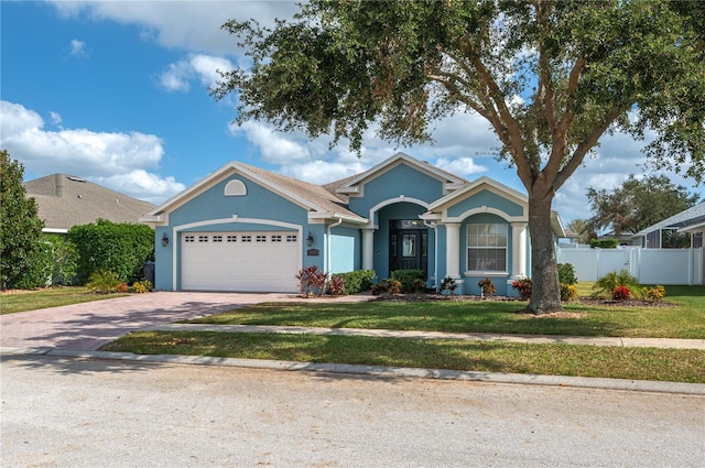 single story home featuring a garage and a front lawn