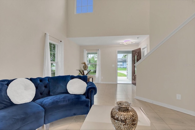 living room with a towering ceiling and light tile patterned floors