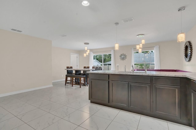 kitchen with a chandelier, dark brown cabinets, and decorative light fixtures