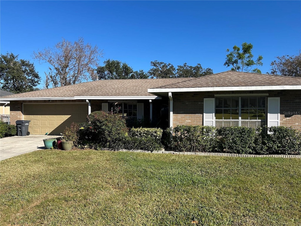 ranch-style home with a front yard and a garage