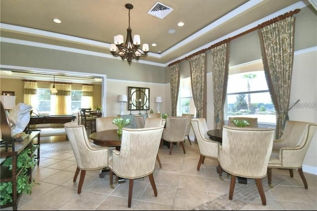 dining area featuring ornamental molding, light tile patterned flooring, a tray ceiling, and an inviting chandelier