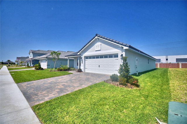 ranch-style house featuring driveway, stucco siding, a front yard, and an attached garage