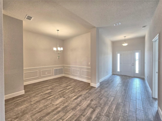 entryway featuring a decorative wall, visible vents, and dark wood finished floors