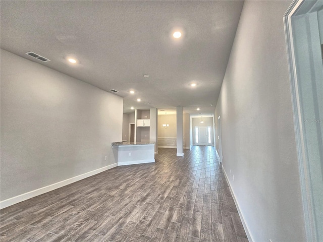 unfurnished living room with recessed lighting, dark wood-style floors, baseboards, and visible vents