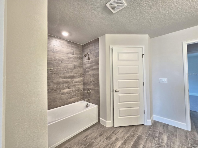 full bathroom with baseboards, visible vents, wood finish floors, and bathing tub / shower combination