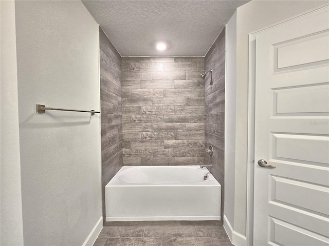 bathroom with baseboards, a textured ceiling, and shower / bathtub combination