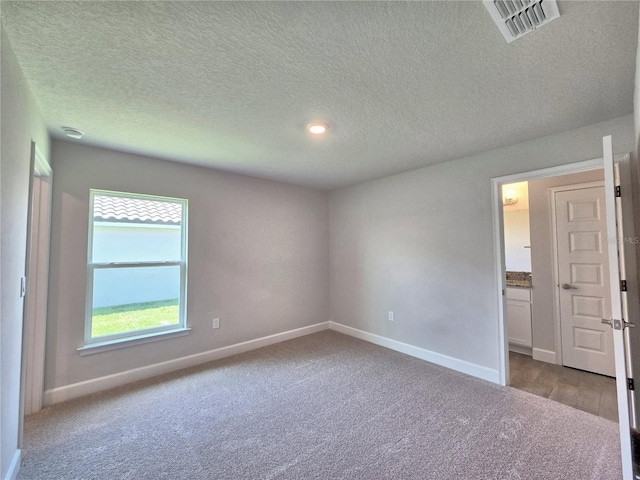 spare room featuring baseboards, visible vents, and carpet
