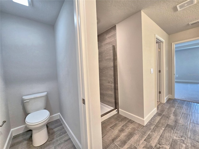 full bathroom with a stall shower, wood tiled floor, and visible vents