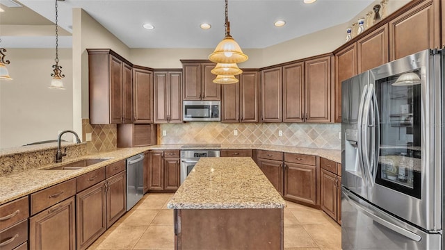 kitchen with tasteful backsplash, appliances with stainless steel finishes, sink, decorative light fixtures, and light stone counters