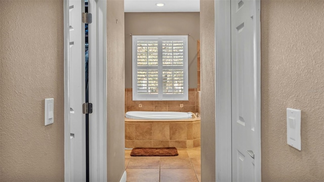 bathroom featuring tiled bath and tile patterned floors