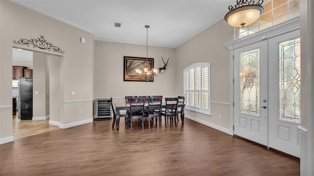 dining room with french doors, crown molding, a chandelier, and dark hardwood / wood-style flooring