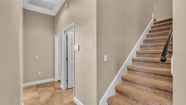 stairway featuring tile patterned flooring