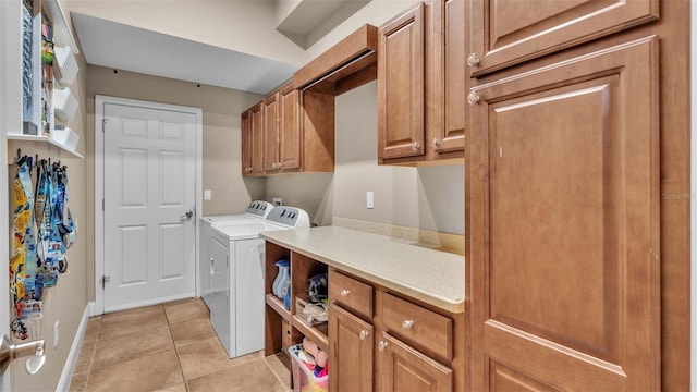 laundry area featuring cabinets, washer and dryer, and light tile patterned flooring