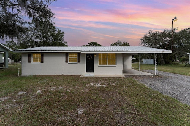 ranch-style home featuring a yard and a carport