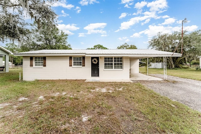 single story home with a front lawn and a carport