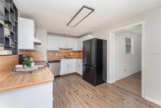 kitchen with tasteful backsplash, dishwasher, black fridge, light hardwood / wood-style floors, and white cabinets