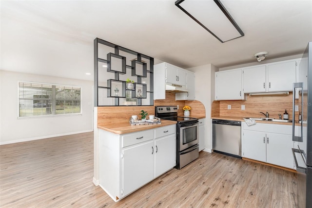 kitchen featuring white cabinets, backsplash, appliances with stainless steel finishes, light hardwood / wood-style flooring, and sink