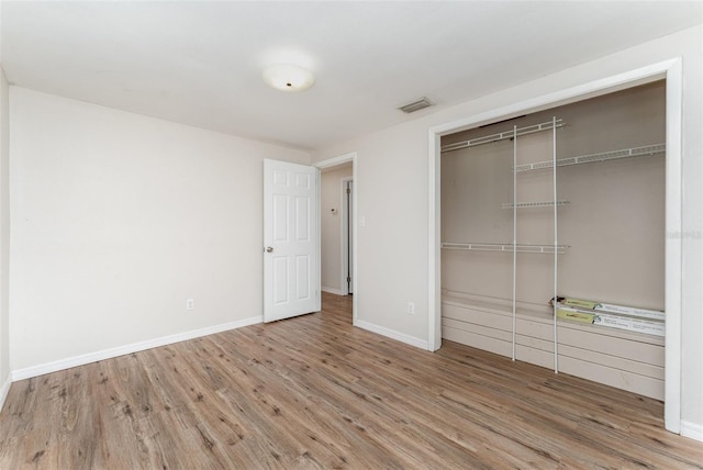 unfurnished bedroom with wood-type flooring and a closet