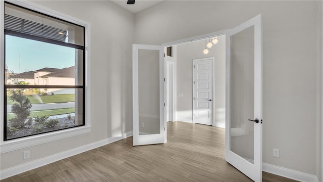 spare room with light hardwood / wood-style flooring and french doors