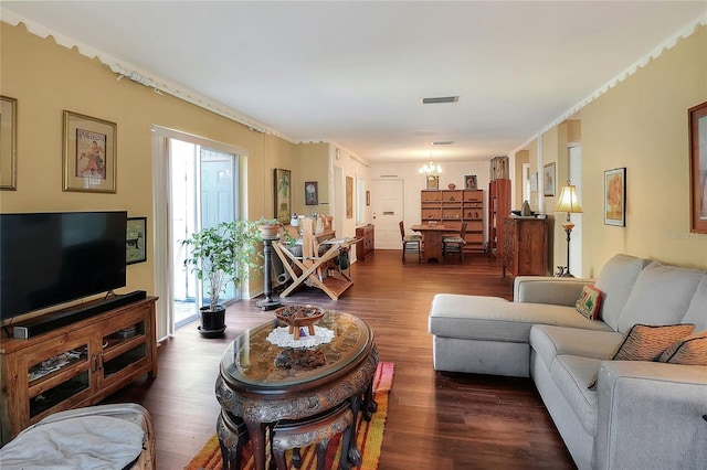 living room with dark hardwood / wood-style floors and an inviting chandelier