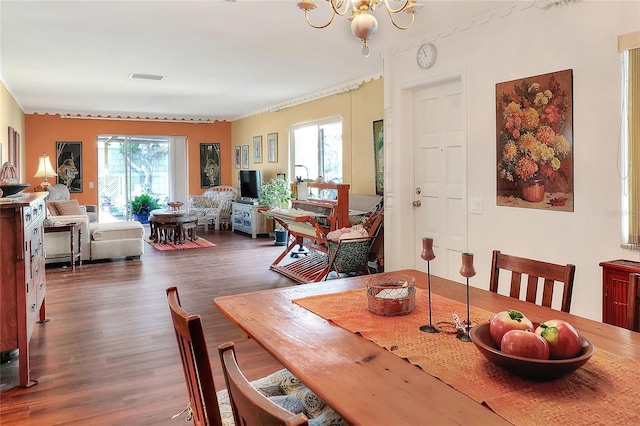 dining space with dark hardwood / wood-style flooring and an inviting chandelier