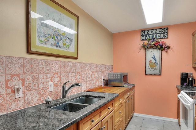 kitchen featuring white electric range, sink, decorative backsplash, dark stone countertops, and light tile patterned flooring