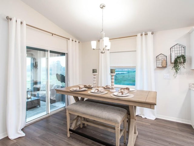 dining area with lofted ceiling, dark wood-type flooring, and an inviting chandelier