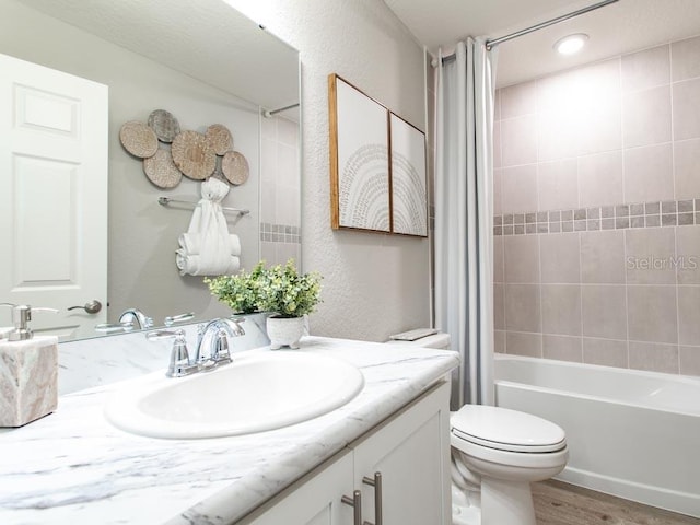 full bathroom featuring toilet, hardwood / wood-style floors, shower / tub combo with curtain, and vanity