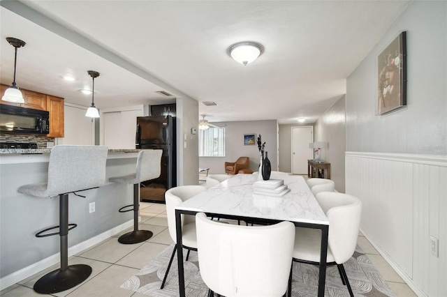 tiled dining area featuring ceiling fan