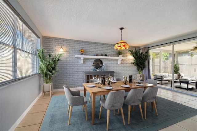 dining space with plenty of natural light, light tile patterned floors, and brick wall