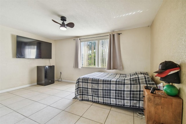 tiled bedroom with ceiling fan and a textured ceiling