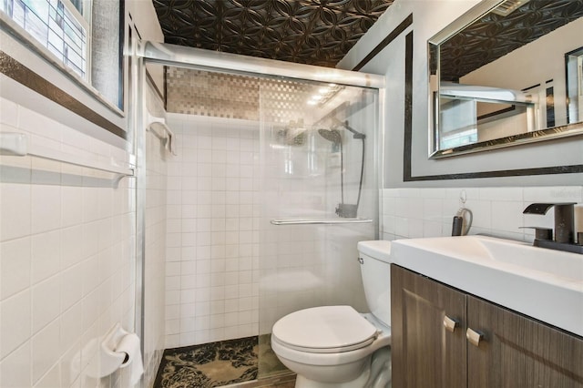 bathroom featuring vanity, toilet, tile walls, and a shower with shower door